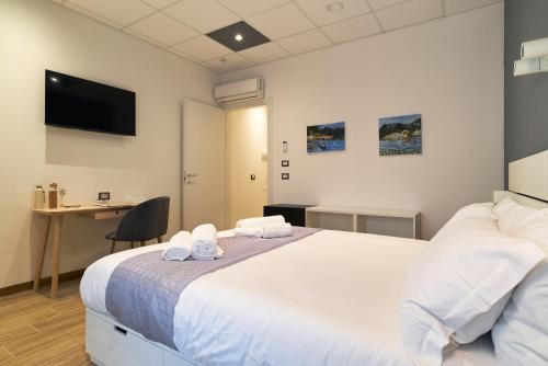 a bedroom with a large white bed and a desk at B&Bike Como Lake in Castelmarte