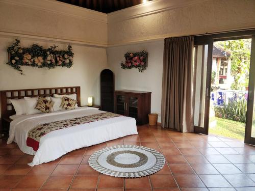 ein Schlafzimmer mit einem großen Bett und einem großen Fenster in der Unterkunft The Dharma Araminth Villa - Lovina Mountain and Sea View in Lovina