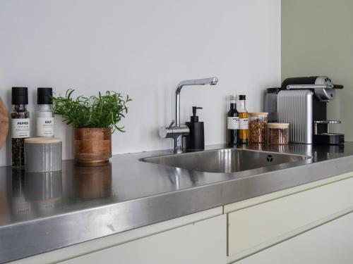 a kitchen counter with a stainless steel sink at Sanders Main - Popular Two-Bedroom Duplex Apartment Next to Magical Nyhavn in Copenhagen