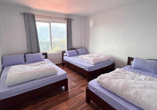 a room with two beds and a window at Dhikidada Resort in Pokhara