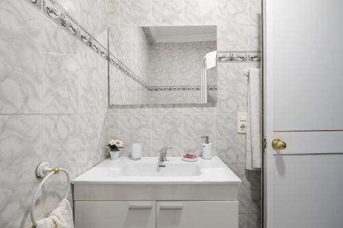 a white bathroom with a sink and a mirror at Estudio con piscina in Cala del Moral
