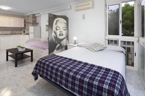 a bedroom with a bed with a plaid blanket at Estudio con piscina in Cala del Moral