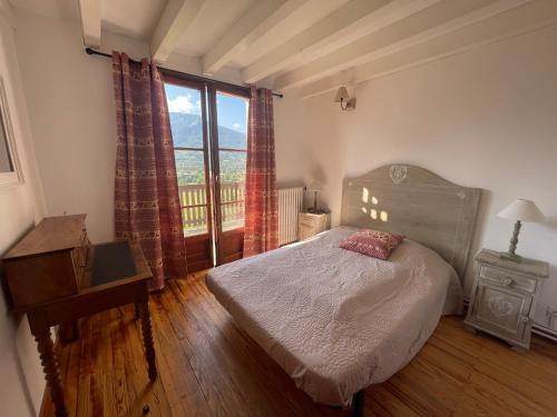 a bedroom with a bed and a large window at La montagnette in Embrun