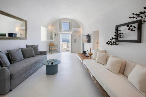 a living room with a couch and a table at Ducato di Oia - Adults Only in Oia