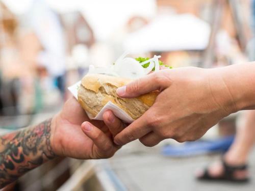 a person holding a sandwich in their hands at Ohlerich Speicher App_ 47 in Wismar