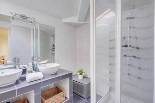 une salle de bain avec deux lavabos et une douche dans l'établissement La Mably Family - Apt spacieux, à Bordeaux