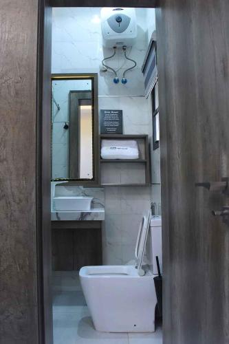 W łazience znajduje się umywalka, toaleta i lustro. w obiekcie Castle Estate Apartments w mieście Abudża