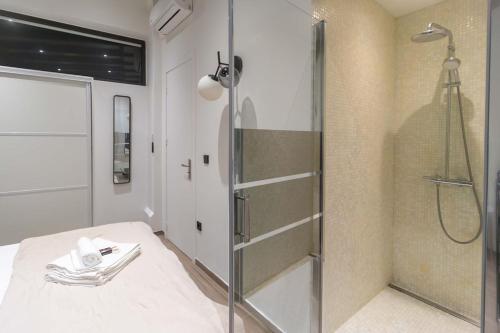 パリにあるApartment Saint Germain des Près by Studio prestigeのバスルーム(シャワー、ベッド、ガラス張りのシャワーブース付)が備わります。