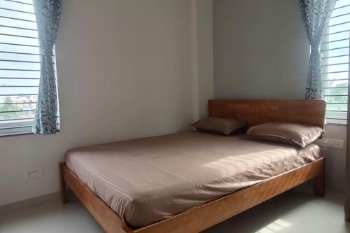 1 cama en un dormitorio con 2 ventanas en Compact yet beautiful 1bhk 001, en Bangalore