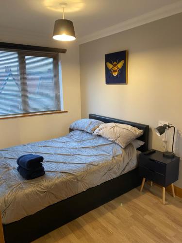 a bedroom with a bed and a lamp and a window at 1 bedroom apartment in Norwich city centre in Norwich