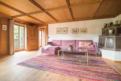 a living room with a purple couch and a table at Das Schusterhäusl - Urlaub im oberbayerischen Baudenkmal in Samerberg