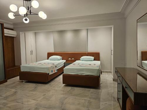 1 dormitorio con 2 camas, tocador y espejo en شقة فندقية, en El Cairo