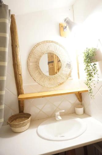 une salle de bain avec un miroir et un lavabo dans l'établissement Gite familial proche Font-Romeu jardin sauna, à Targassonne