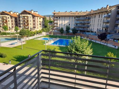 ハカにあるApartamentos Pilartxo Jaca 3000のプールと建物の景色を望むアパートメントバルコニー