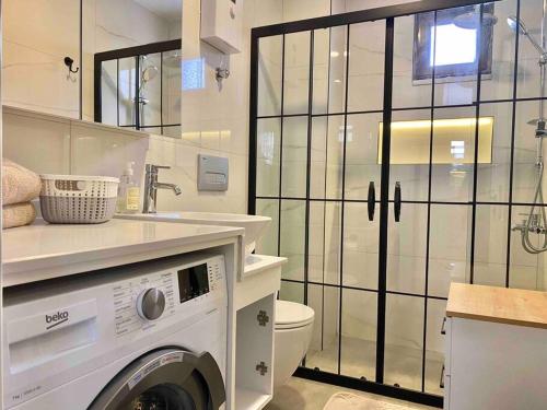 a bathroom with a washing machine and a sink at Camelia 2 Beautiful 1+1 on Cleopatra in Alanya