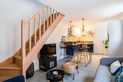 a living room with a staircase leading to a kitchen at Petite maison de charme à 10 minutes de Disney ! in Montévrain