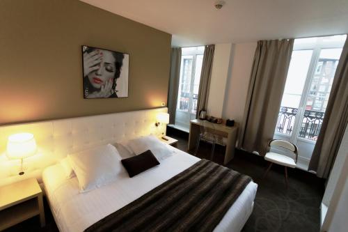 um quarto de hotel com uma cama e duas janelas em Le Saint Louis em Amiens