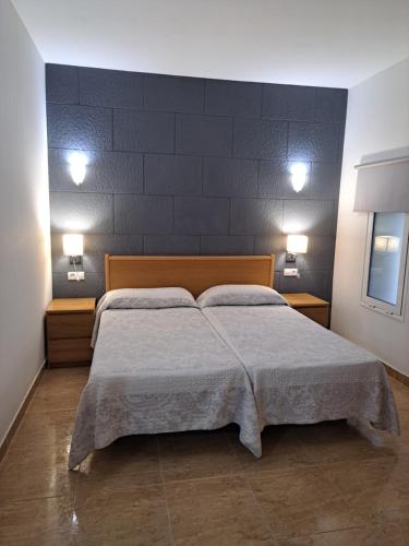 een slaapkamer met een bed met twee lampjes aan de muur bij Edificio Prieto VIV 2B in Puerto del Rosario
