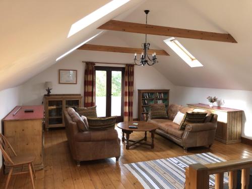 a living room with two couches and a table at Holsworthy Holiday Cottages in Holsworthy