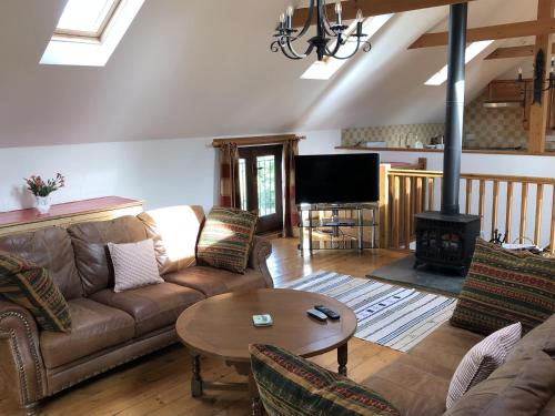 ein Wohnzimmer mit einem Sofa und einem Tisch in der Unterkunft Holsworthy Holiday Cottages in Holsworthy