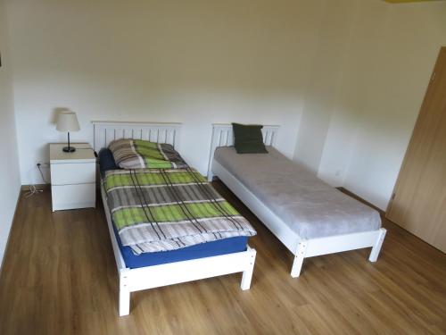 two twin beds in a room with wooden floors at Haus am Park in Thallwitz