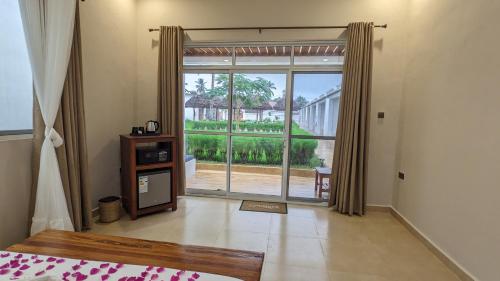 a bedroom with a large glass door leading to a patio at Mafia Dream Hotel in Kilindoni