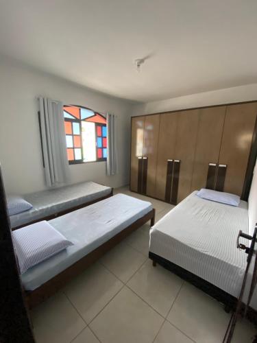a bedroom with two beds and a window at Casa em Santa Teresa-ES in Santa Teresa