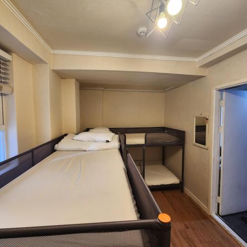a room with two beds and a bunk bed at Joy Guesthouse in Seoul