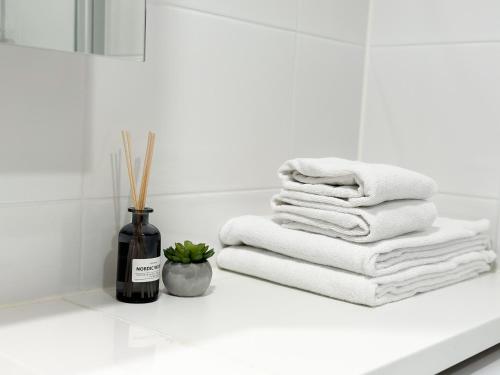 a white bathroom with towels and a bottle of wine at Hostit Arctic Apartments in Rovaniemi