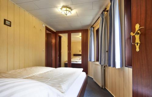 um quarto com uma cama branca num quarto em Hotelschiff Stinne em Wustrow
