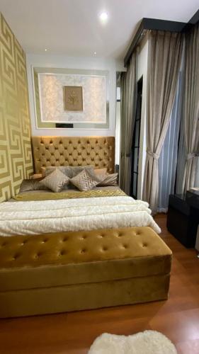 - une chambre avec un grand lit et une grande tête de lit dans l'établissement Emerald Guesh House Type Paris Purwokerto, à Purwokerto