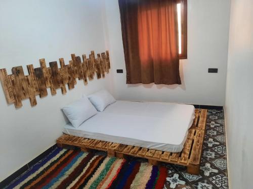 a small room with a bed and a window at Boilers Surf House in Tamri