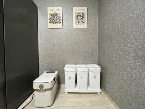 une salle de bains avec deux toilettes et trois photos sur le mur dans l'établissement Our House Near Songtan Station, à Pyeongtaek