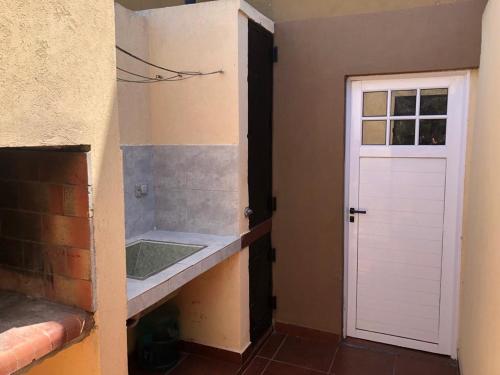 a bathroom with a sink and a white door at Casa Dúplex Nueva Atlantis - Complejo San Norberto in Mar de Ajó