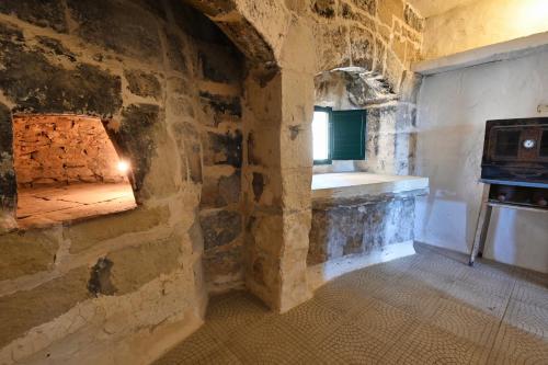 a room with a stone wall with a stove at Mill House in Għarb