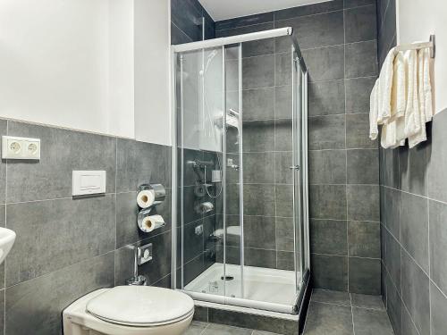 a bathroom with a shower and a toilet at Hotel im Hegen in Oststeinbek