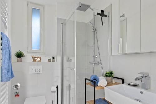 a white bathroom with a shower and a sink at Altstadt - Exklusive 3-Zi-Wohnung 90qm mit großer Dachterrasse in Nuremberg