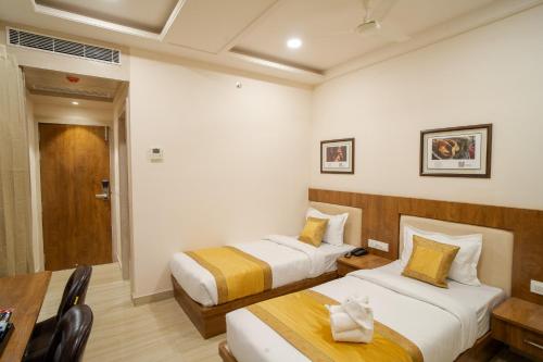 a hotel room with two beds and a table at The Triana in Varanasi