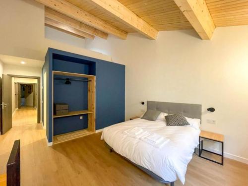 a bedroom with a large bed and a blue wall at San Isidoro Coliving in Oviedo