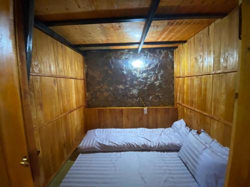 a small room with a bed in a wooden wall at Triệu Chương Homestay in Cao Bằng