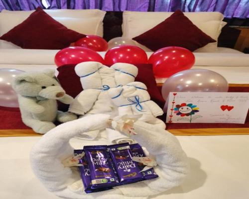 a group of stuffed teddy bears and balloons on a bed at Amaira Resort & Farms - Mirik, West Bengal in Mirik