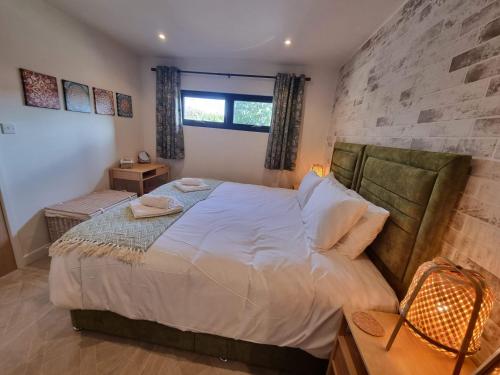 Rudgleigh Lodge by Cliftonvalley Apartments في بريستول: غرفة نوم بسرير كبير وجدار حجري
