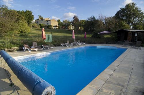 une grande piscine avec un toboggan aquatique dans l'établissement Panorama Gîtes Certes, à Gaudiès