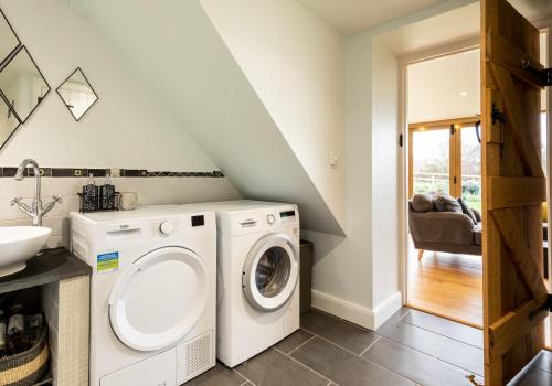 a laundry room with a washer and dryer at Penrhiw - a country cottage with mountain views in Newport