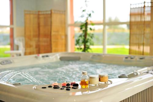 a jacuzzi tub with bottles of essential oils in it at Résidence Goélia La Grande Plage in Saint-Gilles-Croix-de-Vie