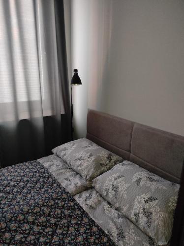 a bedroom with a bed and a lamp and a window at Rose Apartament in Brwinów