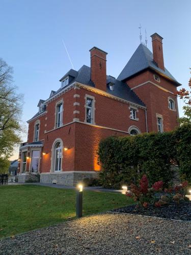a large red brick house with lights in the yard at So'House Manor in Spa