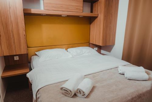 a bedroom with a bed with two towels on it at Poseidon Mobile Home Resort in Makarska