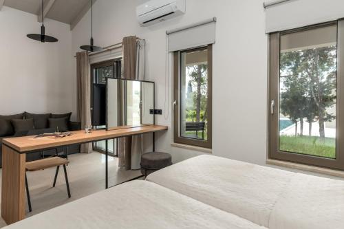 a bedroom with a bed and a desk with a mirror at Alekos Beach Houses-Akrotiri Suites in Kounopetra