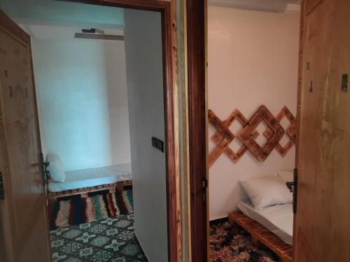 a door to a room with a bed in a room at Boilers Surf House in Tamri